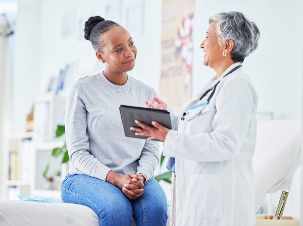 A healthcare provider talking to a patient in a medical consultation, showing a supportive and informative discussion.